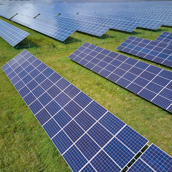 Aerial view of large sustainable electrical power plant with rows of solar photovoltaic panels for producing clean electric energy. Concept of renewable electricity with zero emission.